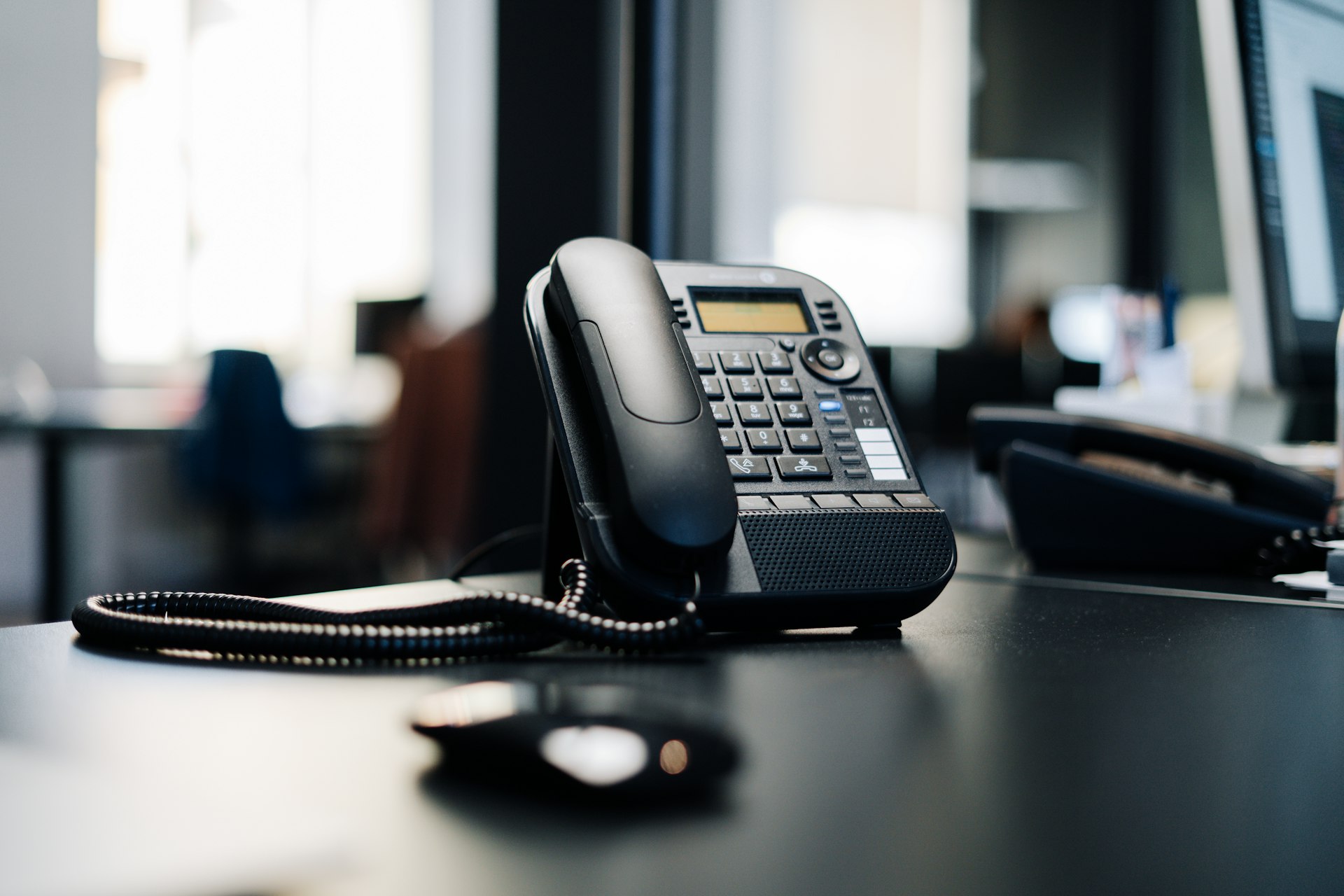 Black desk phone on a professional workspace