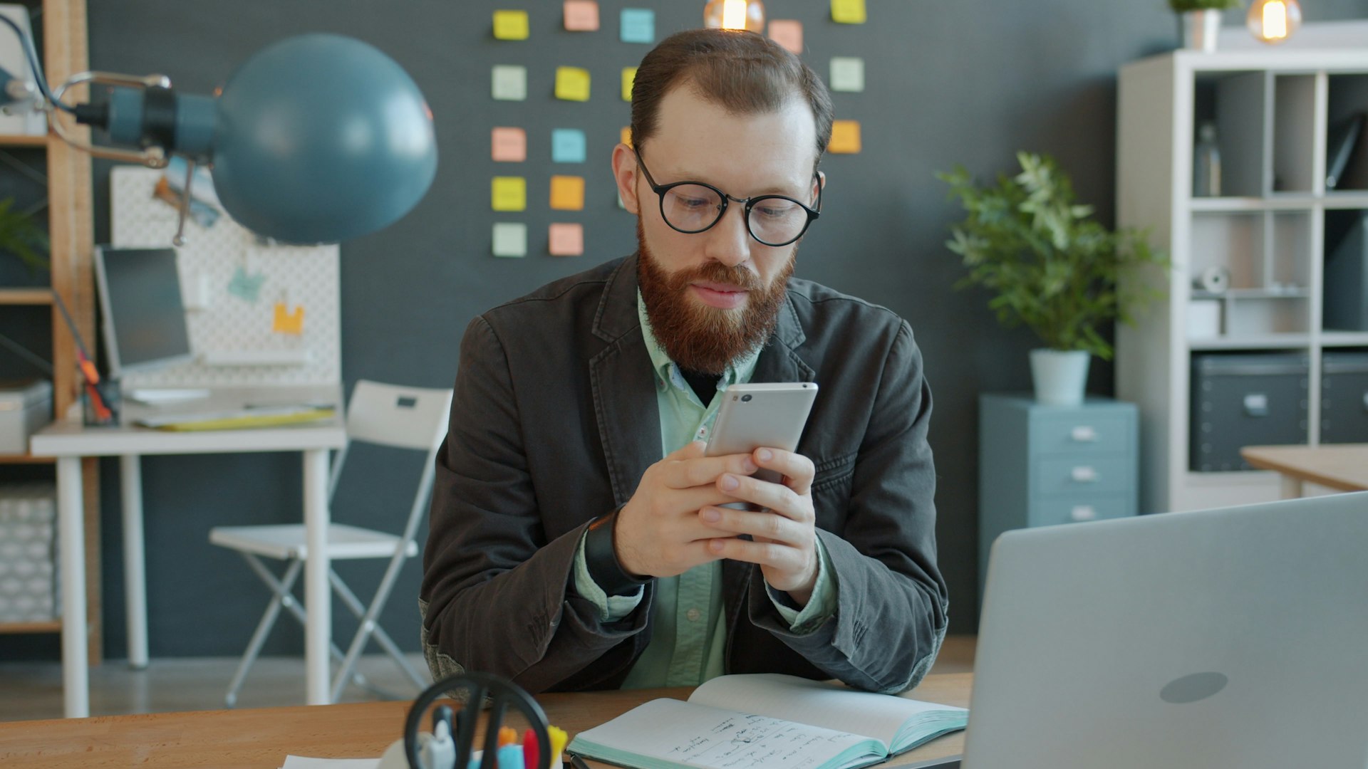 Professional using smartphone at office desk