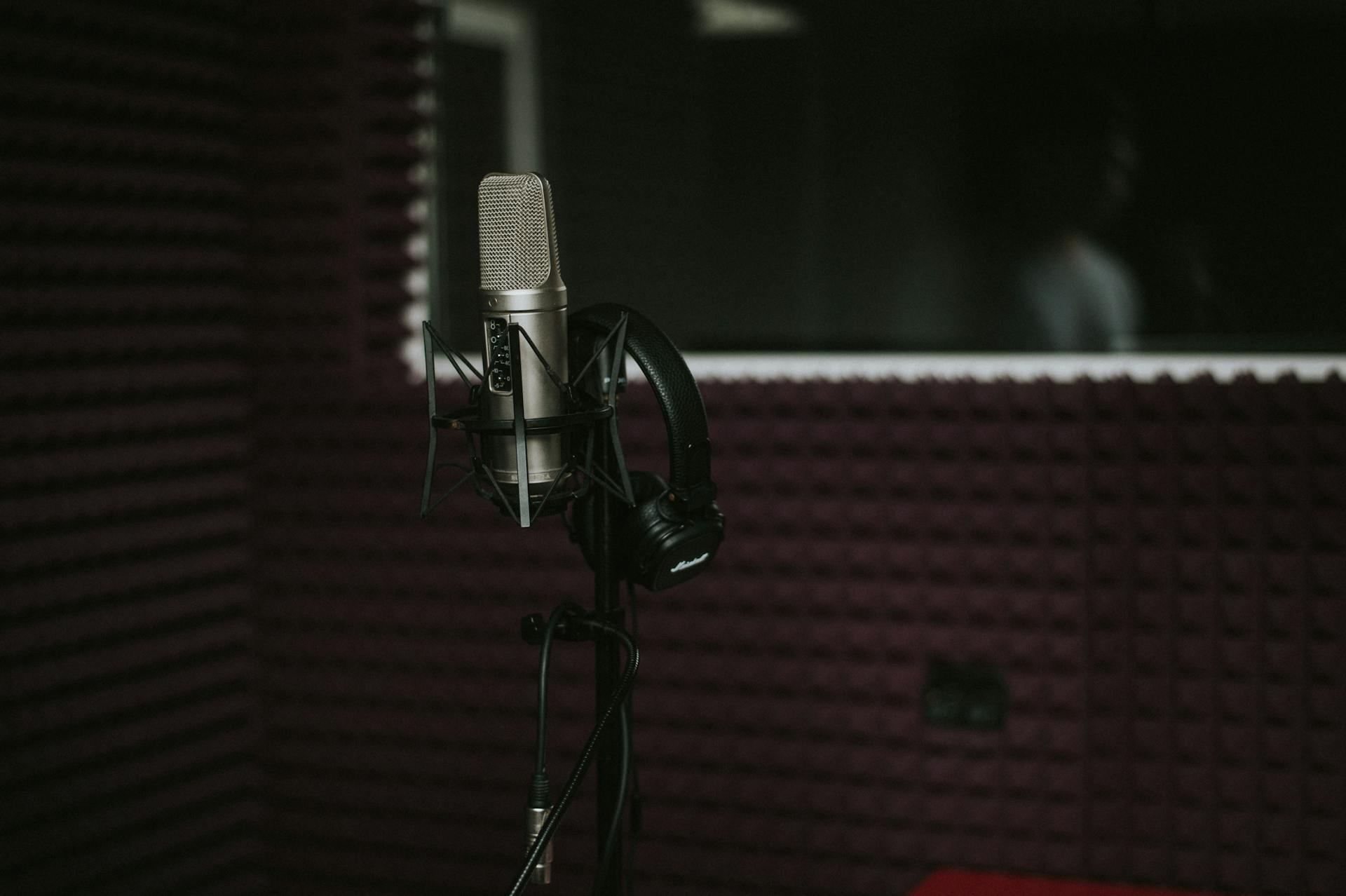 A professional podcasting studio setup with microphone, audio interface, and soft lighting