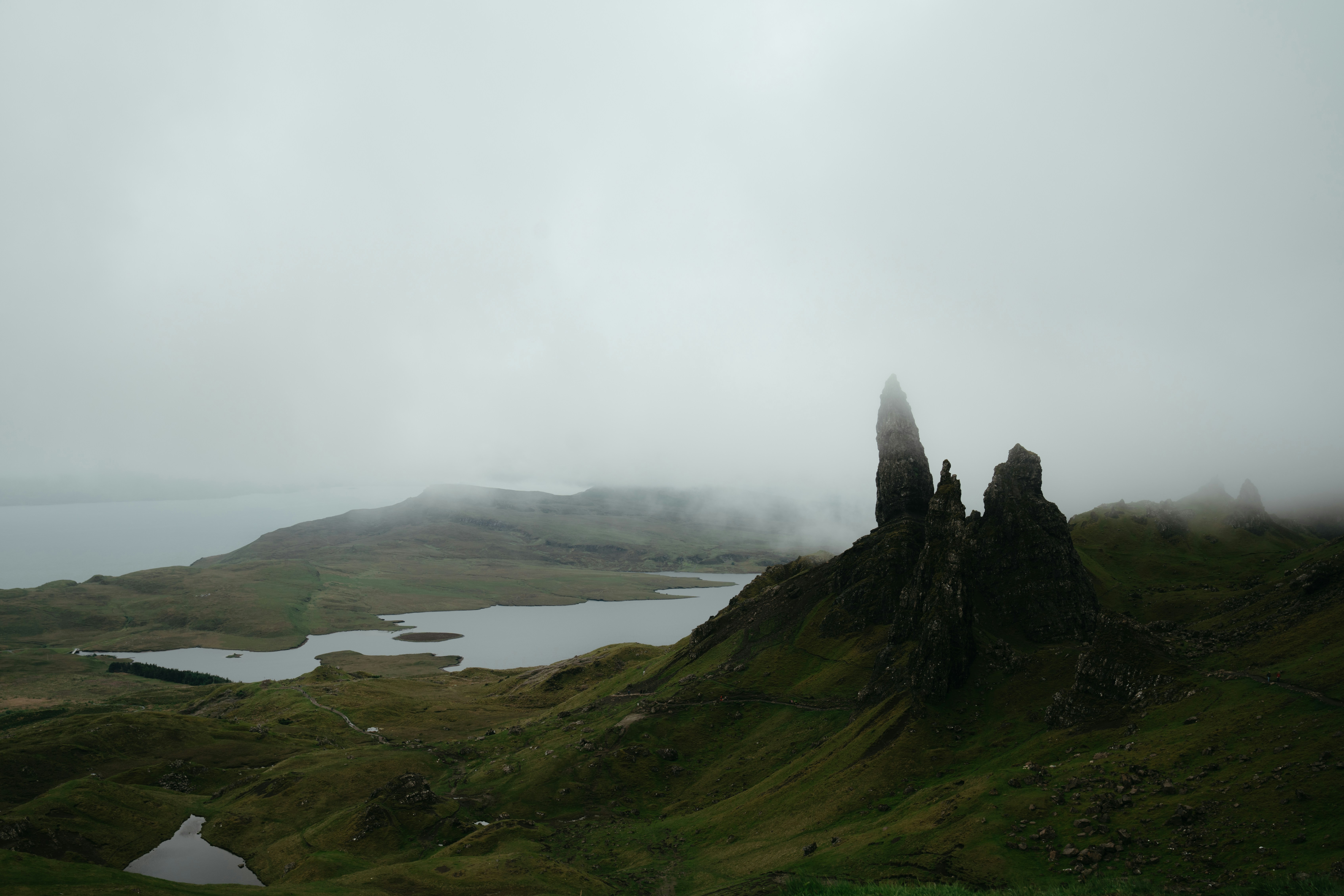 Dramatic Scottish highlands with misty mountains and a dark lake in the foreground