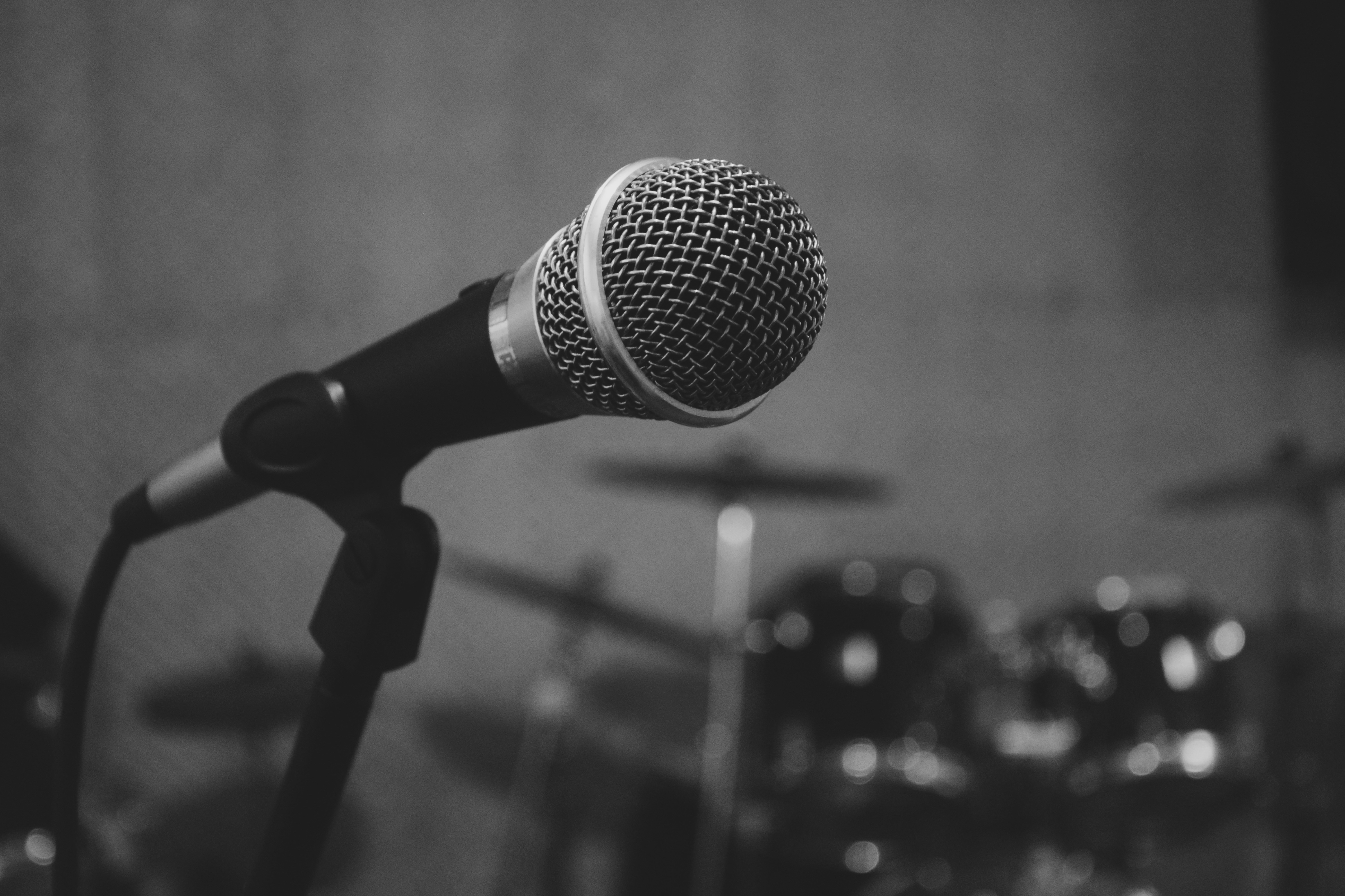Microphone in a dark studio with sound waves illustrated behind it